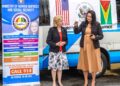 Minister of Human Services and Social Security, Dr. Vindhya Persaud (right) collects the keys to the 17-seat bus from U.S. Ambassador to Guyana Sarah-Ann Lynch