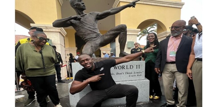 Retired sprint legend Usain Bolt strikes his iconic pose in front of his bronze sculpture at the Ansin Sports Complex in Miramar on Saturday, July 15, 2023.