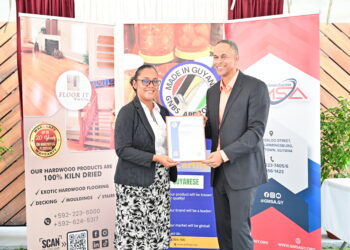 CEO of Floor It Guyana, Mr. Andre Cummings receives the GNBS Made in Guyana Certificate from GNBS Head of Standardisation Services, Ms. Andrea Mendonca.