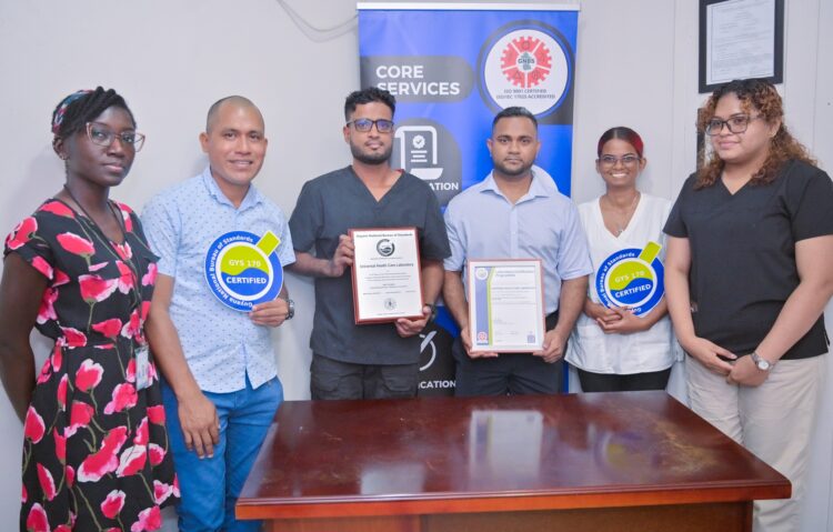 Laboratory Director of Universal Health Care Laboratory, Dr. Ravi Persaud receives GNBS Certificate from GNBS Technical Officer, Ms. Rosmarie Liliah.