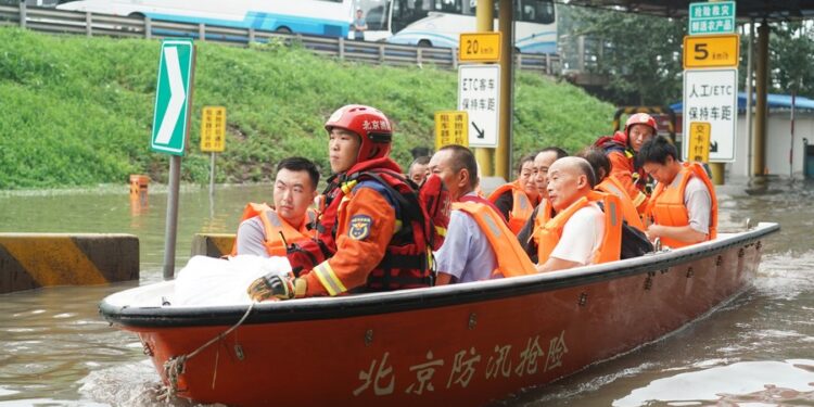 People take a rescue boat to a transshipment point in Fangshan District of Beijing, capital of China, Aug. 2, 2023. (Xinhua/Ren Chao)