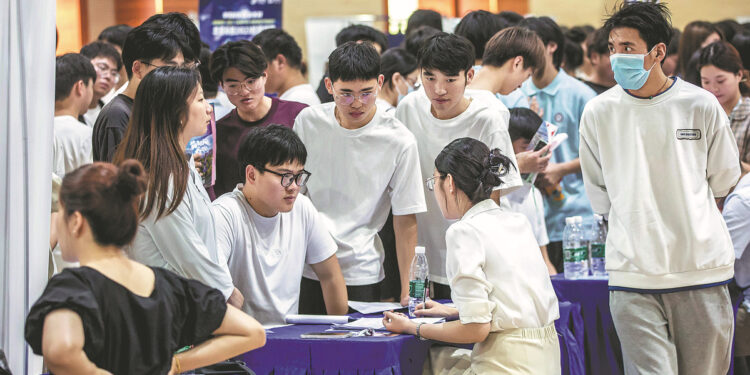 Fresh graduates are interviewed at a job fair held at the Jiangsu Vocational College of Electronics and Information in Huaian, Jiangsu province, on June 15. [Photo provided to China Daily]