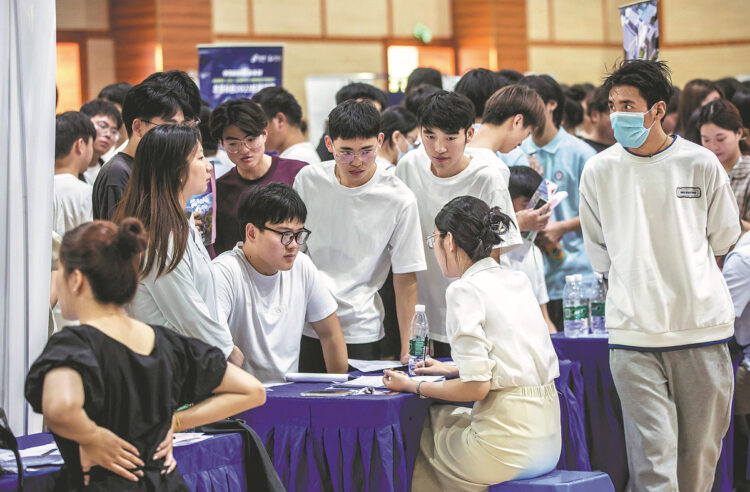 Fresh graduates are interviewed at a job fair held at the Jiangsu Vocational College of Electronics and Information in Huaian, Jiangsu province, on June 15. [Photo provided to China Daily]
