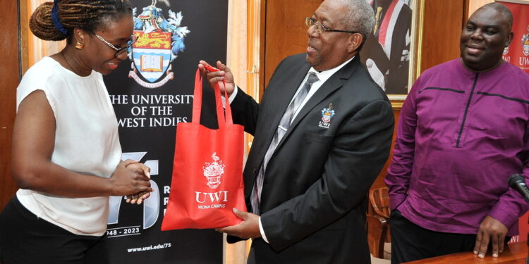 Former Principal Dale Webber (Center) presents Afua Gaisie (Left) with a token of appreciation post signing of a MOU between The UWI and the Ghana Scholarship Secretariat which will allow 25 Ghanaians the opportunity to study at The UWI Mona as Campus Registrar, Dr Donovan Stanberry (Right) smiles approvingly.