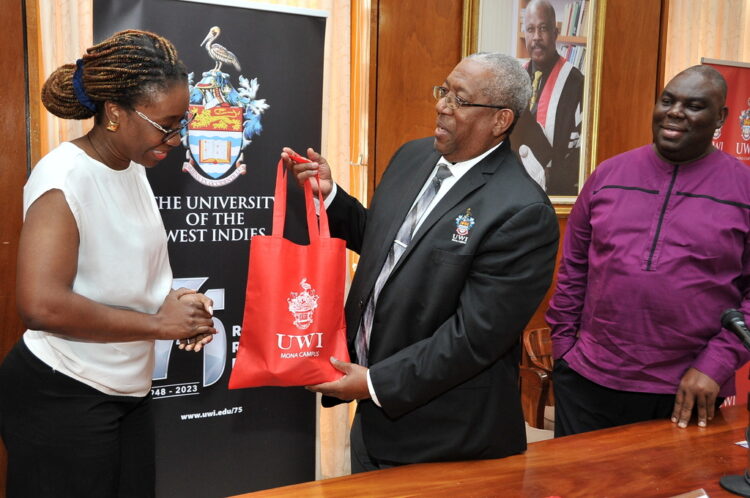 Former Principal Dale Webber (Center) presents Afua Gaisie (Left) with a token of appreciation post signing of a MOU between The UWI and the Ghana Scholarship Secretariat which will allow 25 Ghanaians the opportunity to study at The UWI Mona as Campus Registrar, Dr Donovan Stanberry (Right) smiles approvingly.