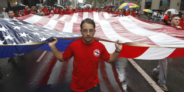 File - Local 361 iron worker Robert Farula marches up Fifth Ave. carrying an American flag during the Labor Day parade on Sept. 8, 2012 in New York. Labour Day, 2023, is right around the corner. And while many may associate the holiday with major retail sales and end-of summer barbecues, Labour Day’s roots in worker-driven organising feel especially significant this year. (AP Photo/Mary Altaffer, File)