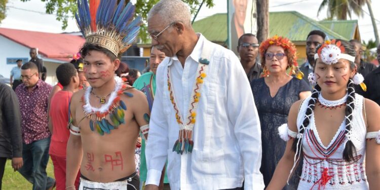 Former President David Granger (c) with two Indigenous children