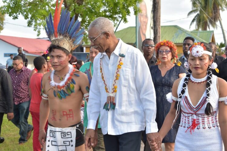 Former President David Granger (c) with two Indigenous children