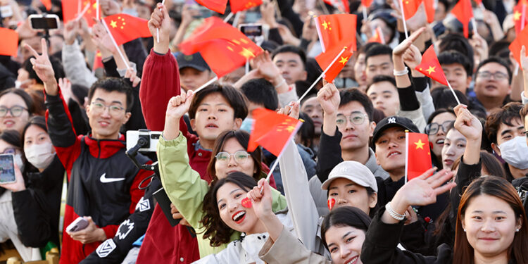 People wave national flags to celebrate the 74th anniversary of the founding of the People's Republic of China, in Tian'anmen Square in Beijing on Oct 1, 2023. [Photo by Zhu Xingxin/China Daily]