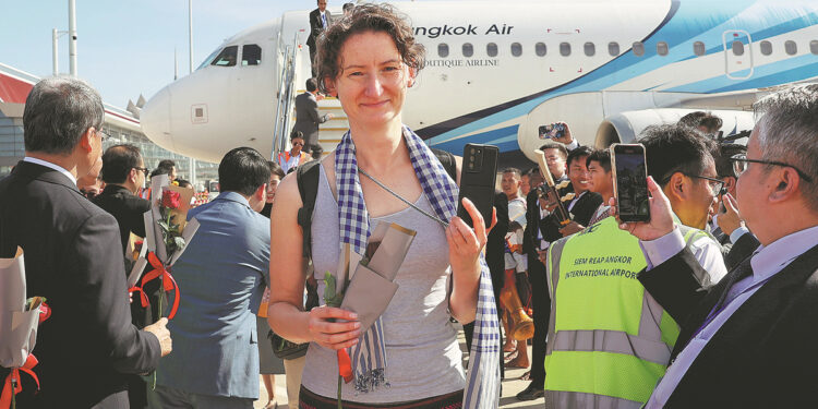 A traveler deplanes from the first passenger flight to arrive at Siem Reap-Angkor International Airport in Cambodia on Monday. [Photo by Hu Xinlin/For China Daily]