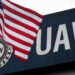 An American flag flies in front of the United Auto Workers union logo on the front of the UAW Solidarity House in Detroit, Michigan, September 8, 2011. Two years after the wrenching restructuring of the U.S. auto industry and the bankruptcies that remade General Motors and Chrysler, the UAW is facing its own financial reckoning. Picture taken September 8, 2011. To match Special Report USA-AUTOS/UNION REUTERS/Rebecca Cook (UNITED STATES - Tags: BUSINESS EMPLOYMENT TRANSPORT) Acquire Licensing Rights