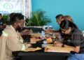Global Tech officials assist applicants fill out forms during their job fair at C3 Centre, San Fernando. The fair is geared towards individuals seeking employment in the Guyana market. - AYANNA KINSALE