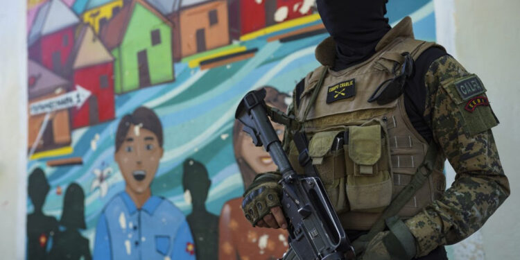 A soldier passes in front of a mural in Tutunichapa, a historical area for drug trafficking in the Salvadoran capital. On December 24, 2022, President Nayib Bukele deployed more than one thousand troops in the district to extract gang members. © Getty Images