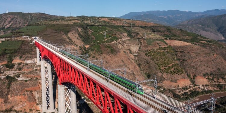 This aerial photo taken on Nov. 23, 2022 shows a Fuxing bullet train running on the Yuanjiang bridge of the China-Laos Railway in southwest China's Yunnan Province. (Xinhua/Hu Chao)