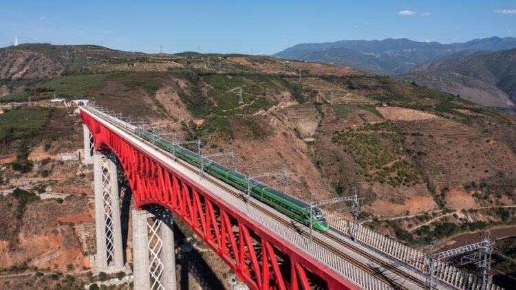 This aerial photo taken on Nov. 23, 2022 shows a Fuxing bullet train running on the Yuanjiang bridge of the China-Laos Railway in southwest China's Yunnan Province. (Xinhua/Hu Chao)