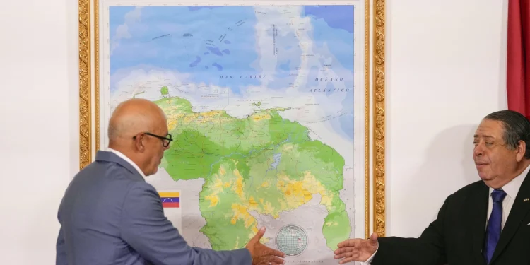 National Assembly President Jorge Rodriguez, left, and Chairman of the Special Commission for the Defense of Guyana Essequibo Hermann Escarra, shake hands after unveiling Venezuela's new map that includes the Essequibo territory, a swath of land that is administered and controlled by Guyana but claimed by Venezuela, in Caracas, Venezuela, Friday, Dec. 8, 2023. (AP Photo/Matias Delacroix)