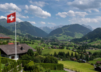 A Swiss flag and the Alps surrounding the resort of Gstaad in Saanen municipality, July 23, 2023. /CFP