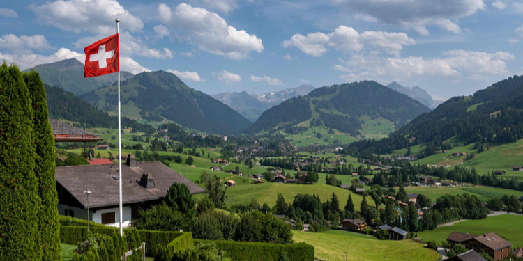A Swiss flag and the Alps surrounding the resort of Gstaad in Saanen municipality, July 23, 2023. /CFP