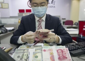 A bank employee is counting currency in north China's Shanxi Province, March 13, 2020. /CFP