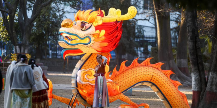 A girl poses for photos with a dragon-shaped light decoration during a lantern show in Kathmandu, Nepal, Feb 7, 2024. [Photo/Xinhua]