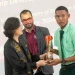 Head of the Unit of Allied Arts, Nicholas Fraser and Chinese Ambassador to Guyana, Guo Haiyan handing over one of the prizes to a student