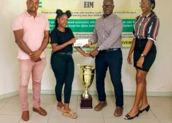 One of the members of EIM, Andrew Hercules (second, right) hands over the donation to Mash Street Football Championship Ambassador, Terryann Caesar yesterday while Edison Jefford (left) and another share the moment.