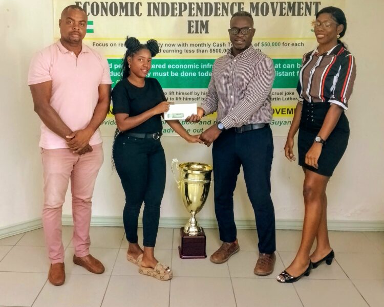 One of the members of EIM, Andrew Hercules (second, right) hands over the donation to Mash Street Football Championship Ambassador, Terryann Caesar yesterday while Edison Jefford (left) and another share the moment.