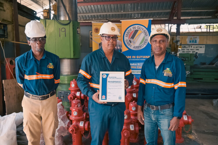 (L-R) BACIF Quality Control Manager Mr. Adrian Barkoye, Managing Director Mr. Peter Pompey and Operations Manager Mr. Rondel Ali poses with the GNBS Certificate on Feb. 8
