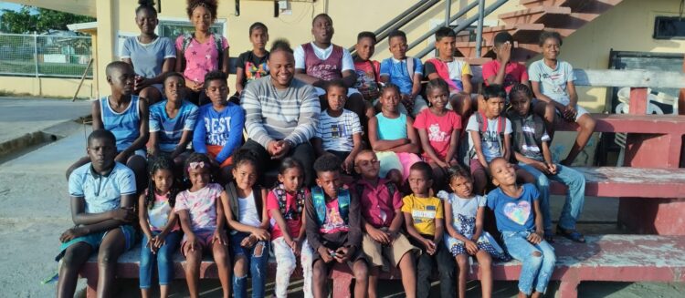 Coach Andrew poses with the young scholars from the Angoy's Avenue Learning Pod