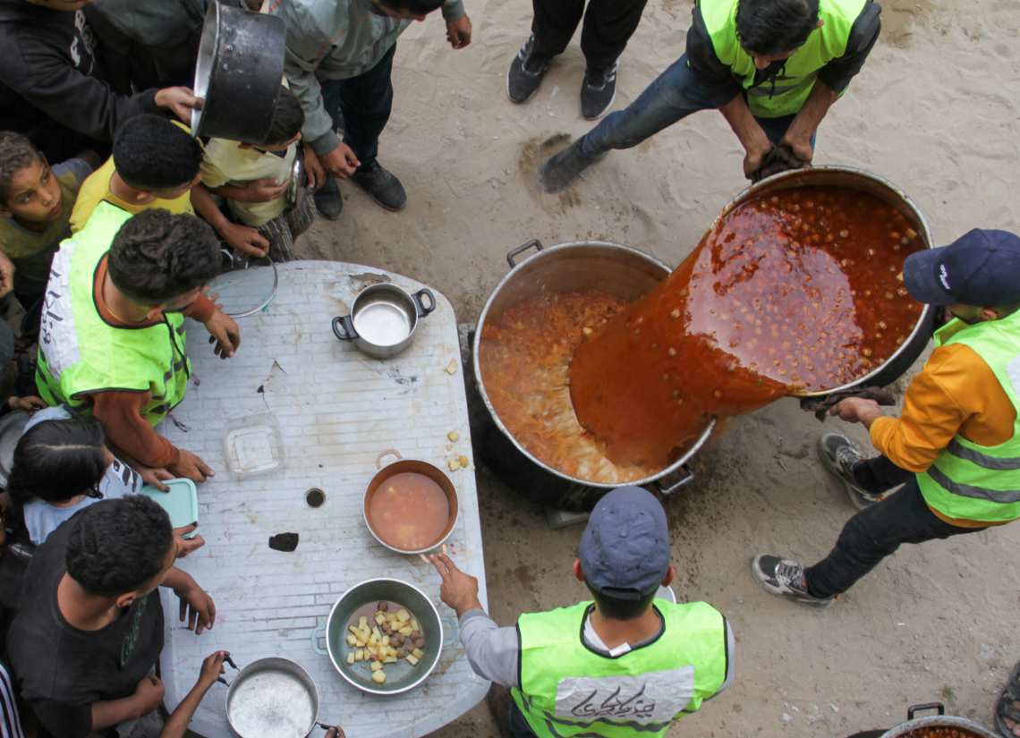 Volunteers feed displaced families in Jabalia./Mahmoud Issa/REUTERS
