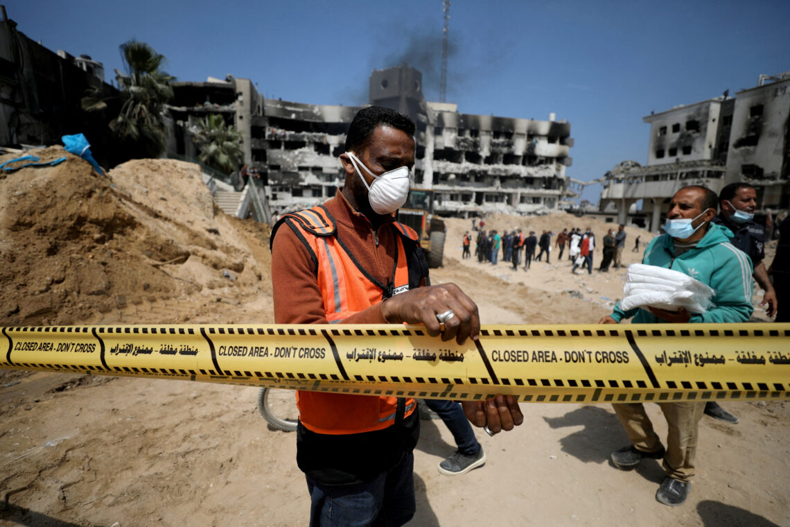 FILE PHOTO: A man tapes off the area as rescuers and medics search for dead bodies inside the damaged Al Shifa Hospital after Israeli forces withdrew from the hospital and the area around it following a two-week operation, amid the ongoing conflict between Israel and Palestinian Islamist group Hamas, in Gaza City April 8, 2024. REUTERS/Dawoud Abu Alkas/File Photo