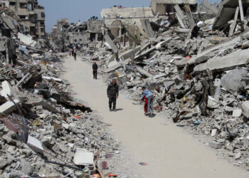 [1/3] Palestinians walk past the ruins of houses in the northern Gaza Strip March 31, 2024. REUTERS/Mahmoud Issa/File Photo Purchase Licensing Rights