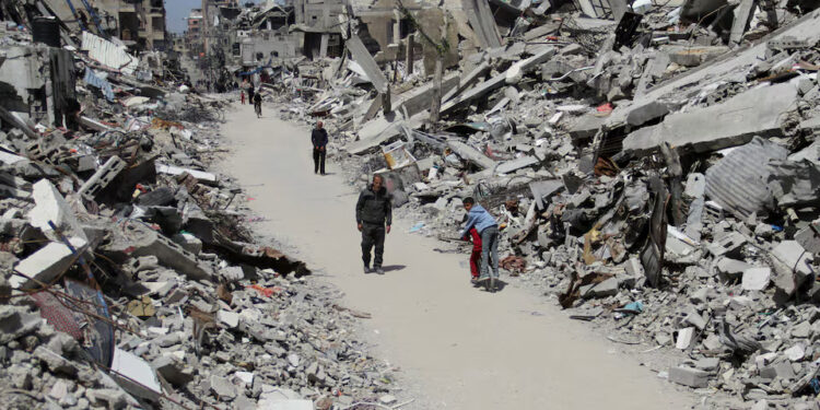 [1/3] Palestinians walk past the ruins of houses in the northern Gaza Strip March 31, 2024. REUTERS/Mahmoud Issa/File Photo Purchase Licensing Rights