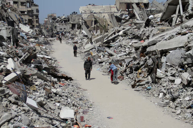[1/3] Palestinians walk past the ruins of houses in the northern Gaza Strip March 31, 2024. REUTERS/Mahmoud Issa/File Photo Purchase Licensing Rights