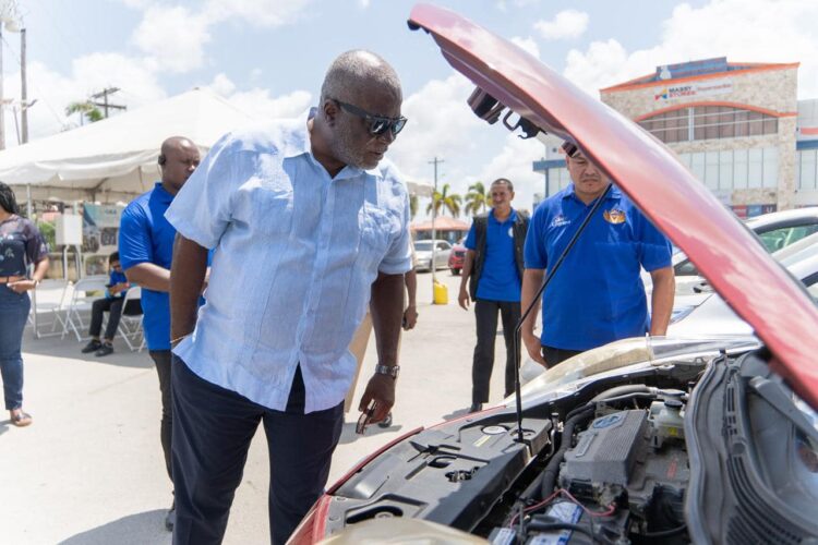 Prime Minister, Brigadier (Ret'd) Mark Phillips examines an electric vehicle (EV) on display during the GEA’s inaugural EV Show and Tell Exhibition at the Amazonia Mall, Providence held in March 2024.