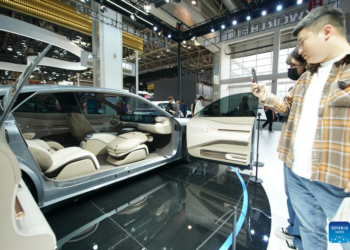 People watch a vehicle at the booth of Skyworth Auto at the 2024 Beijing International Automotive Exhibition in Beijing, China, April 30, 2024.