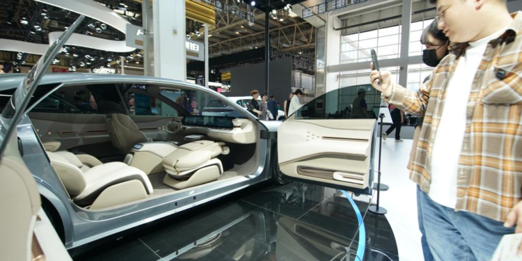 People watch a vehicle at the booth of Skyworth Auto at the 2024 Beijing International Automotive Exhibition in Beijing, China, April 30, 2024.