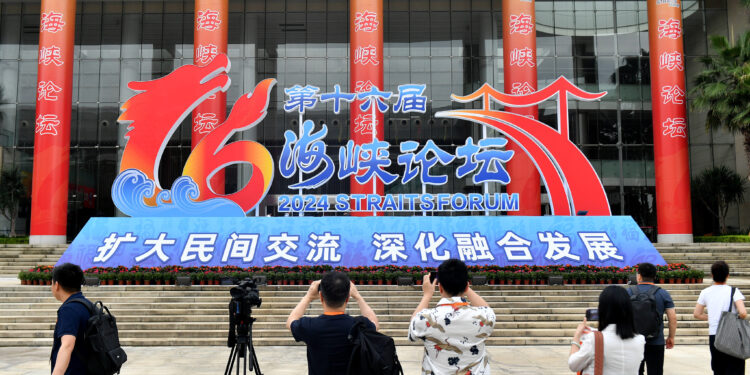 Journalists take photos in front of the primary venue of the 16th Straits Forum in Xiamen City, southeast China's Fujian Province, June 14, 2024. /CFP