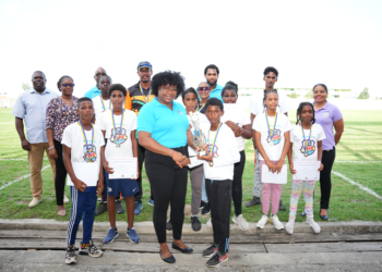 Zaleel Thomas of River Doree Anglican Combined School receives trophy from Florence Demacque, RBEC Vieux Fort- Branch Manager, also in the photo, Director of Sports Clivus Jules, Principal Secretary of the SLNCA Jacqueline Inglis and coaches from Zone 5