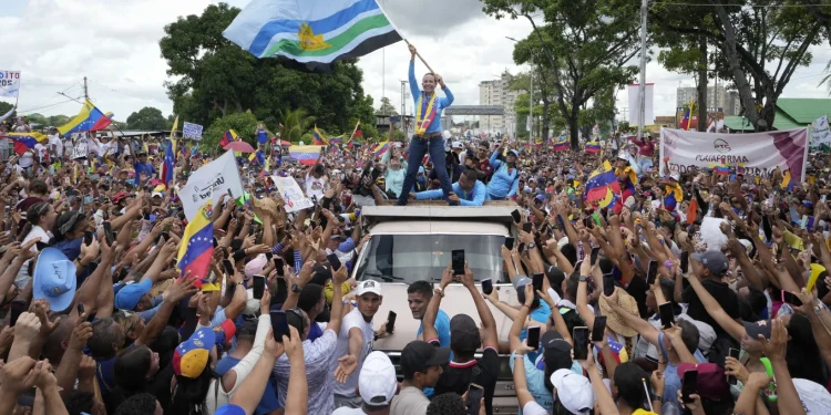 Opposition leader Maria Corina Machado waves a Monagas state flag as she greets supporters during a campaign rally for presidential candidate Edmundo Gonzalez, in Maturin, Venezuela, Saturday, July 20, 2024. The presidential election is set for July 28. (AP Photo/Matias Delacroix)