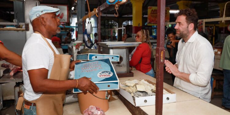 Country Director for the Caribbean and Mexico at the Norwegian Seafood Council, Orjan Olsen speaks with Lloyd Weise about the Norwegian Saltfish that he sells, during his tour of the Cross Roads Market in St Andrew in May.