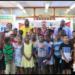 Last row from left: Vice-Chancellor, Professor Paloma Mohamed Martin; UG's Chief Librarian, Mrs Gwyneth George; second from right, Courts Optical Chain Manager, Mr Richard Simpson, along with other UG and Unicomer staff and some of the children who will be participating in this year’s "Reading is Fun" Programme.