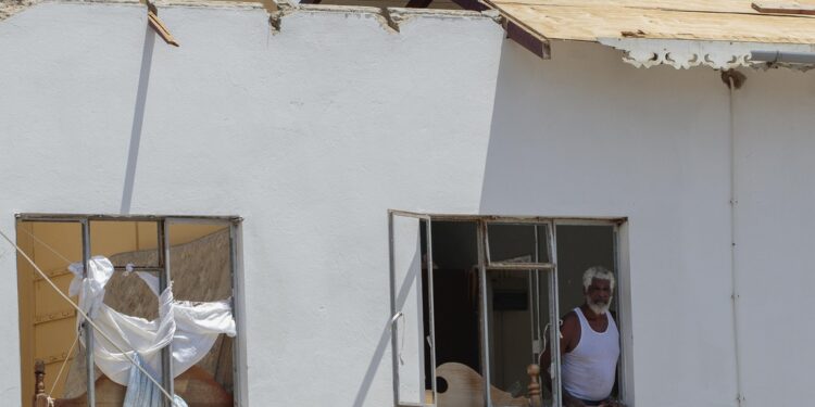 A man looks out of the window of his home, which was destroyed by Hurricane Beryl in Clifton, Union Island, St. Vincent and the Grenadines, Thursday, July 4, 2024. (AP Photo/Lucanus Ollivierre)