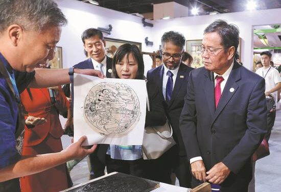 Khambay Damlath (right), vice-president of the Lao National Assembly, learns about New Year woodblock painting, which is listed as a national-level intangible cultural heritage item, in Changzhi, Shanxi province, on Aug 11, 2024. Damlath is on a visit to Changzhi to attend the ASEAN-China Week 2024, which will run through Thursday. (ZHU XINGXIN/CHINA DAILY)