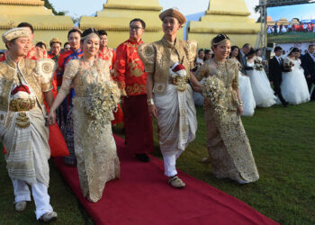 Chinese couples take part in a mass wedding jointly organized by Sri Lankan authorities and the Chinese embassy in the capital of Colombo on Dec 17. Some of the 50 couples wore local traditional clothing for the ceremony in which the hosts tied their little fingers together with cotton threads. [Photo/Agencies]
