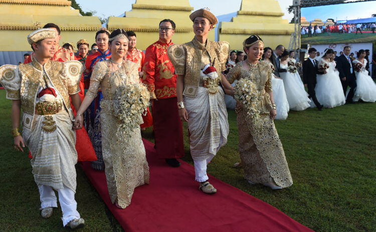 Chinese couples take part in a mass wedding jointly organized by Sri Lankan authorities and the Chinese embassy in the capital of Colombo on Dec 17. Some of the 50 couples wore local traditional clothing for the ceremony in which the hosts tied their little fingers together with cotton threads. [Photo/Agencies]