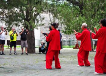 Tourists take photos of citizens practicing Tai Chi at the Tiantan (Temple of Heaven) Park in Beijing, capital of China, July 2, 2024. (Xinhua/Ju Huanzong)