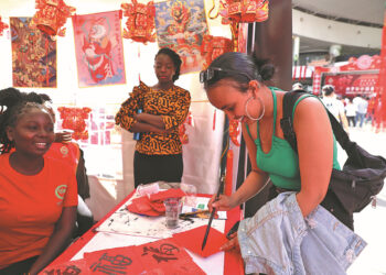 A student from Eritrea learns Chinese calligraphy at a booth set up by the Confucius Institute of Kenyatta University during a Chinese New Year cultural event in Nairobi, Kenya, on Feb 10. WU XIAOHUI/CHINA DAILY