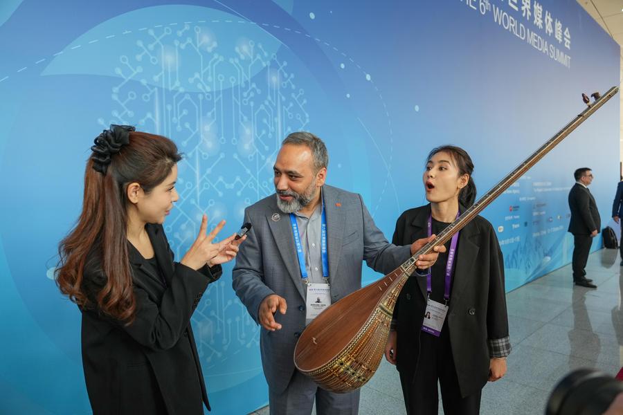 (241014) -- URUMQI, Oct. 14, 2024 (Xinhua) -- A participant tries dutar, a string instrument, at the venue of the opening ceremony of the 6th World Media Summit in Urumqi, capital city of northwest China's Xinjiang Uygur Autonomous Region, Oct. 14, 2024. The 6th World Media Summit opened on Monday morning in Urumqi, capital city of northwest China's Xinjiang Uygur Autonomous Region.
Themed "Artificial Intelligence and Media Transformation," the summit gathered over 500 participants from 106 countries and regions, including representatives of 208 mainstream media outlets, government agencies and international organizations. (Xinhua/Chen Yehua)
