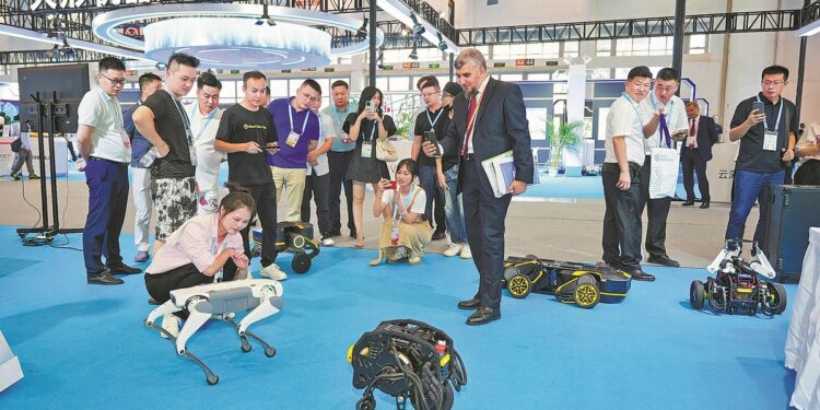 Participants in the BRICS Excellence Training Program on Artificial Intelligence Technology and Governance visit the robot section of the 2024 BRICS New Industrial Revolution Exhibition in Xiamen, Fujian province, in September. [Photo provided to China Daily]